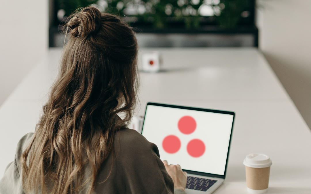 woman sitting at desk working on computer with asana open. asana plans on adding an ai tool to its app