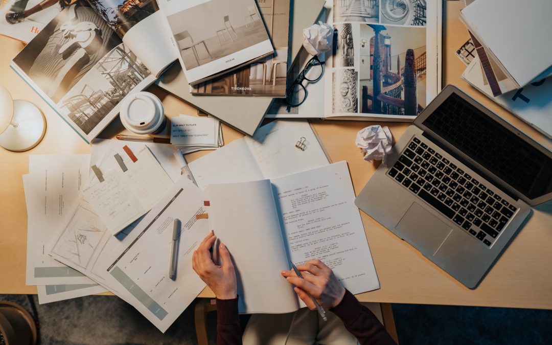 ai-written scripts man sitting at desk reading through script messy desk and laptop