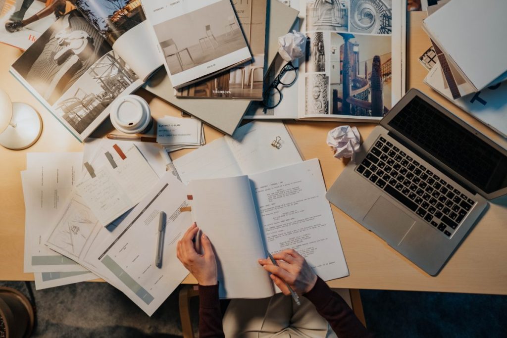 ai-written scripts man sitting at desk reading through script messy desk and laptop